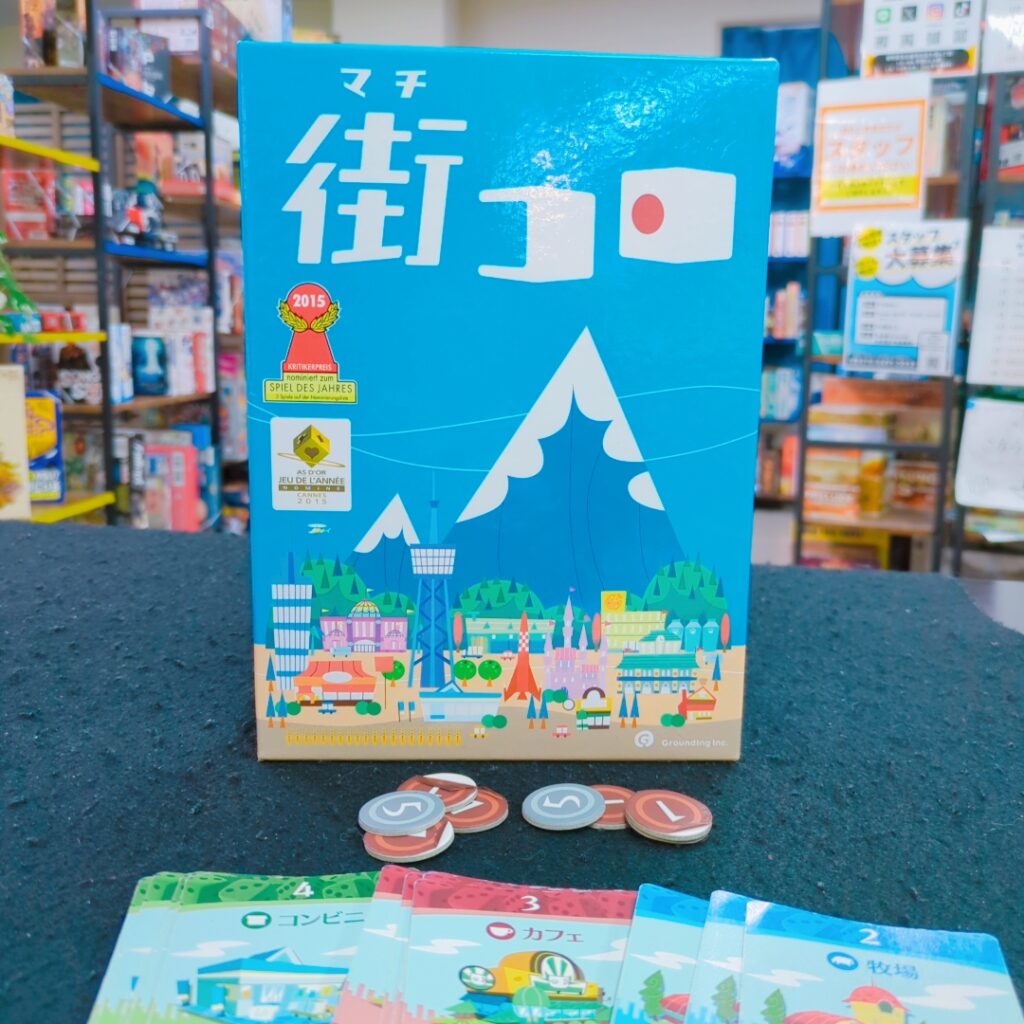 街コロのボードゲームのカードとコインを並べたプレイ風景